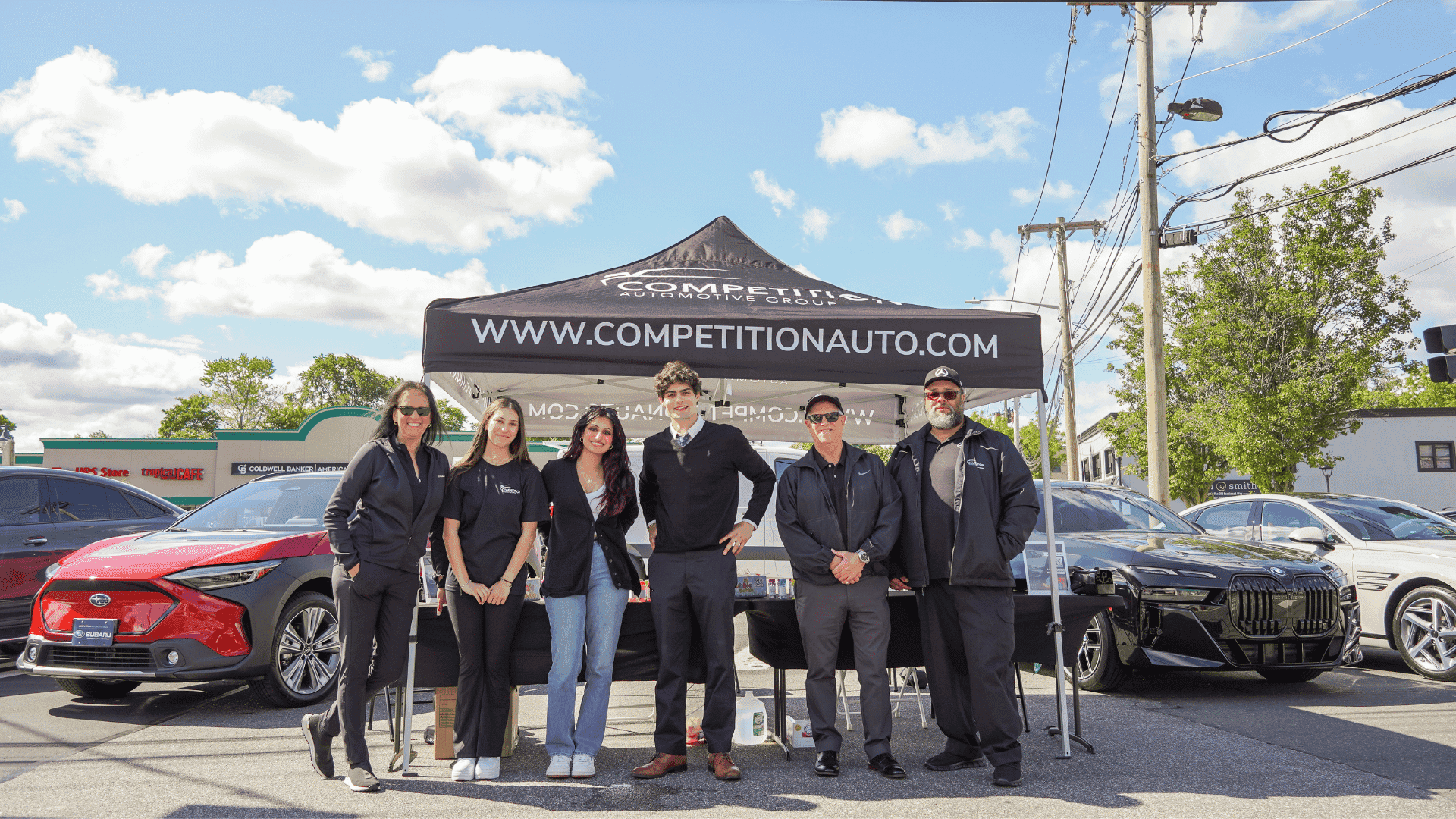 Subaru Motorsports Car Show Team stands front of tent